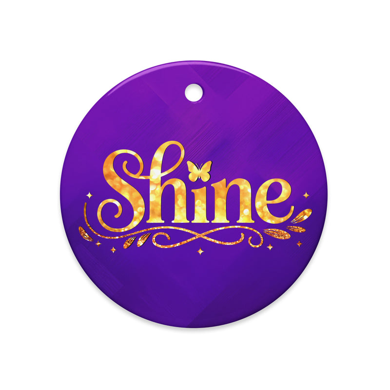 Glossy ceramic Christmas ornament with gold ‘Shine’ lettering on a midnight violet background. Created by Women’s Fiction & Romance Author Juliet Gauvin.