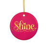Glossy ceramic Christmas ornament with gold ‘Shine’ lettering on a mystic magenta background, hanging from a gold string. Created by Women’s Fiction & Romance Author Juliet Gauvin.