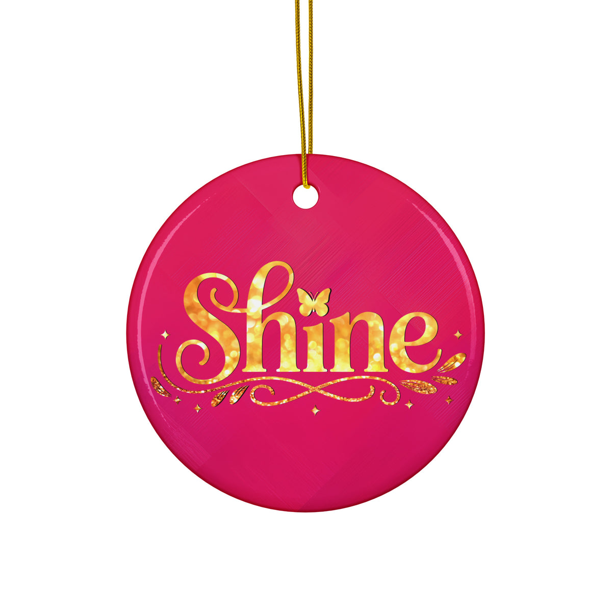Glossy ceramic Christmas ornament with gold ‘Shine’ lettering on a mystic magenta background, hanging from a gold string. Created by Women’s Fiction & Romance Author Juliet Gauvin.