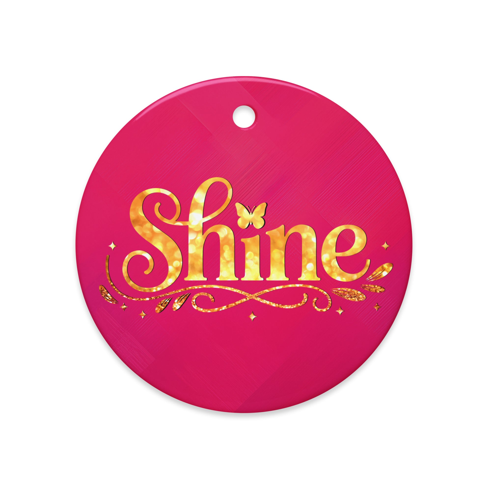 Glossy ceramic Christmas ornament with gold ‘Shine’ lettering on a mystic magenta background. Created by Women’s Fiction & Romance Author Juliet Gauvin.