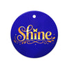 Glossy ceramic Christmas ornament with gold ‘Shine’ lettering on a midnight sapphire background. Created by Women’s Fiction & Romance Author Juliet Gauvin.