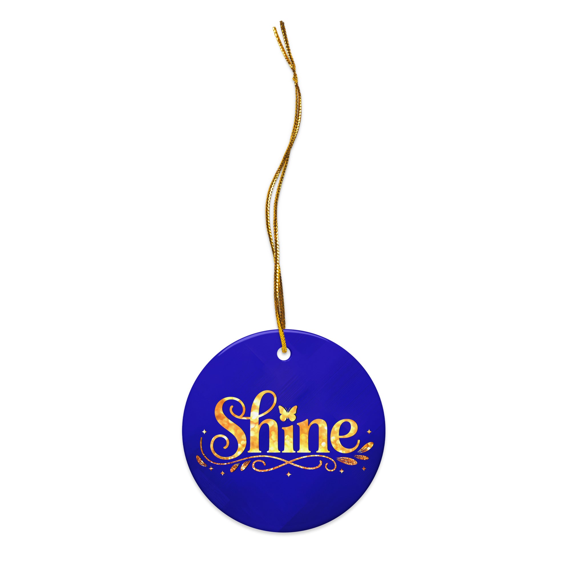 Glossy ceramic Christmas ornament with gold ‘Shine’ lettering on a midnight sapphire background, full gold string. Created by Women’s Fiction & Romance Author Juliet Gauvin.