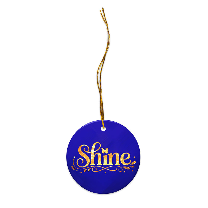 Glossy ceramic Christmas ornament with gold ‘Shine’ lettering on a midnight sapphire background, full gold string. Created by Women’s Fiction & Romance Author Juliet Gauvin.