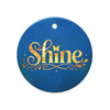 Glossy ceramic Christmas ornament with gold ‘Shine’ lettering on a midnight teal background. Created by Women’s Fiction & Romance Author Juliet Gauvin.