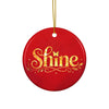 Glossy ceramic Christmas ornament with gold ‘Shine’ lettering on a mags red background, hanging from a gold string. Created by Women’s Fiction & Romance Author Juliet Gauvin.