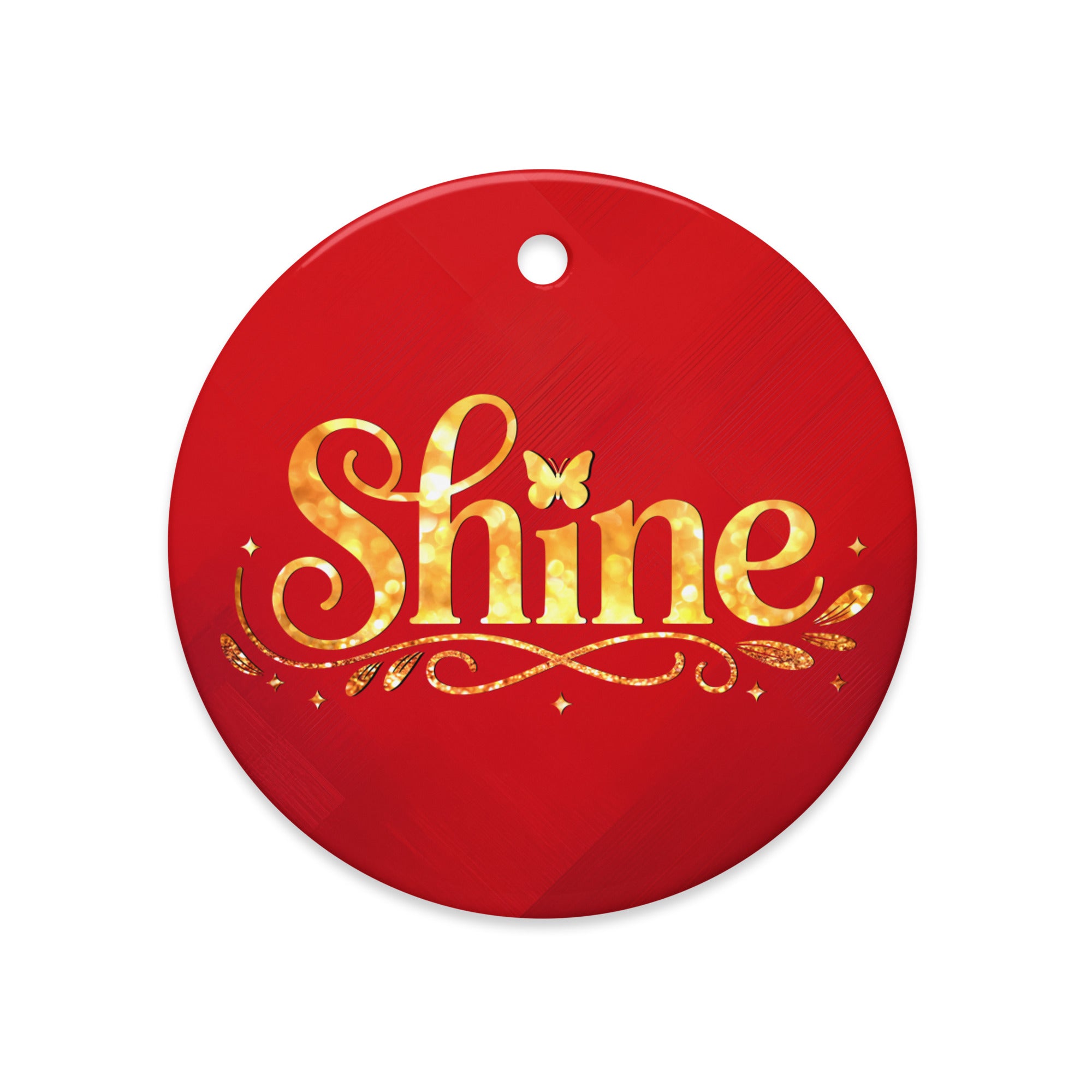 Glossy ceramic Christmas ornament with gold ‘Shine’ lettering on a mags red background. Created by Women’s Fiction & Romance Author Juliet Gauvin.