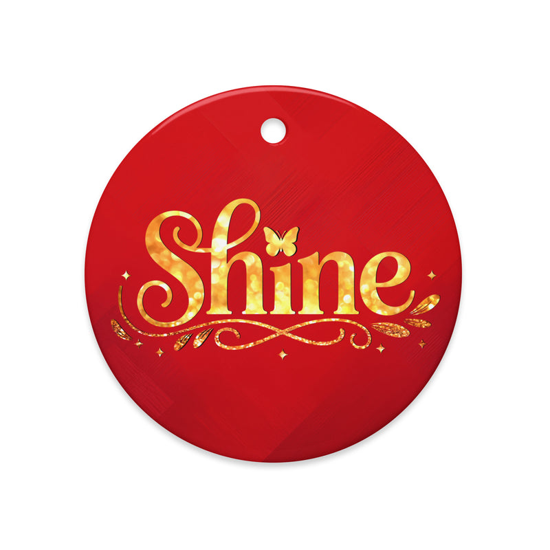Glossy ceramic Christmas ornament with gold ‘Shine’ lettering on a mags red background. Created by Women’s Fiction & Romance Author Juliet Gauvin.