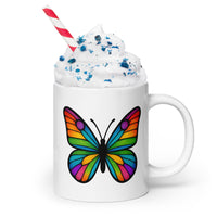 Front view: Juliet’s Butterfly oversized ceramic cocoa mug — 20oz white mug with butterfly design filled with whip cream, blue sprinkles, and a red & white straw.